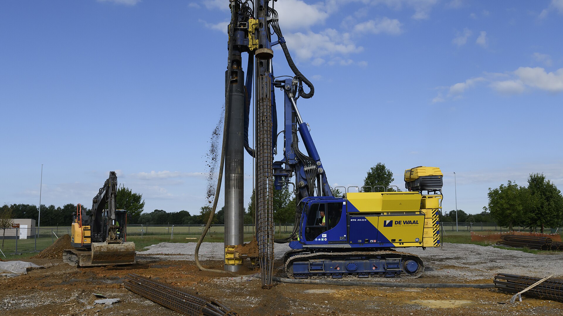 물 트렌드와 관련된 Soil falls from the hydraulic drill as contractors use a piling rig to assemble continuous flight auger piles in place for the foundations of a water reservoir, on Chièvres Air Bas