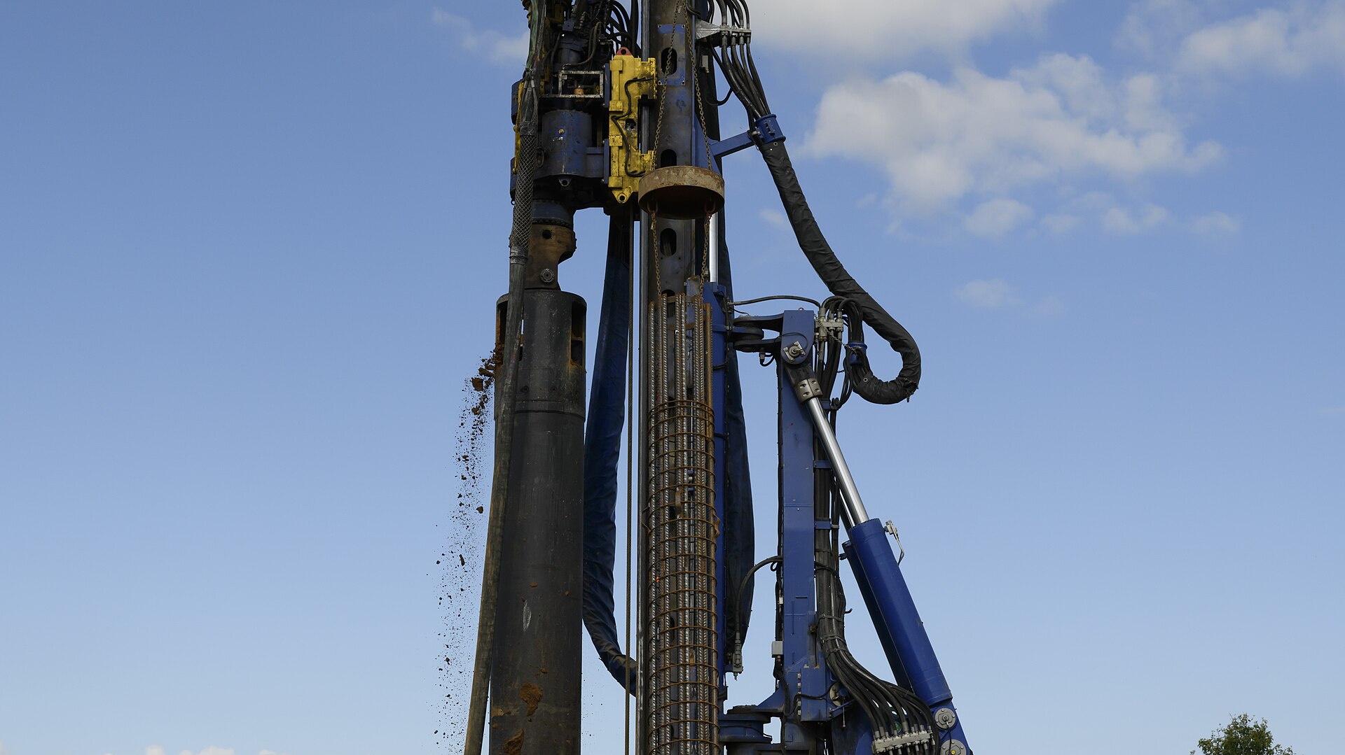 물 트렌드와 관련된 Soils falls from the hydraulic drill as contractors use a piling rig to assemble continuous flight auger piles in place for the foundations of a water reservoir, on Chièvres Air Ba